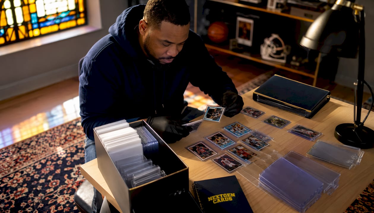 Hands sorting collectible cards with protective sleeves
