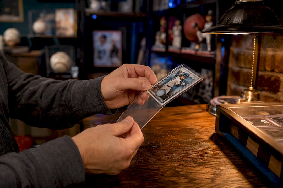 Hands placing card in UV-blocking sleeve