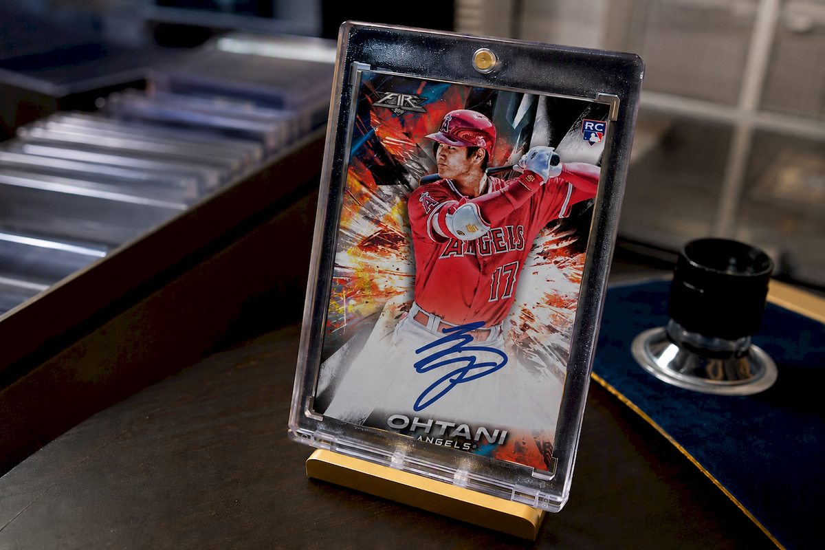 Shohei Ohtani 2018 Topps Fire rookie autograph baseball card displayed in a protective holder on a collector’s desk.